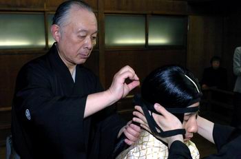 日本能剧艺术大师坂井音重（左）在东京的自家戏台为演员化妆。